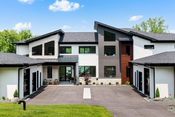 Front of modern custom home with white, brown, and black accents