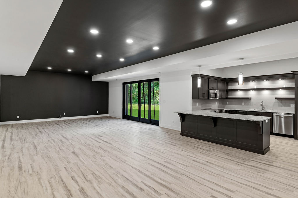 Basement with black ceiling and light wood floors