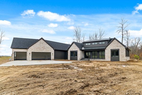 Exterior of custom built home with black roof and light colored stone