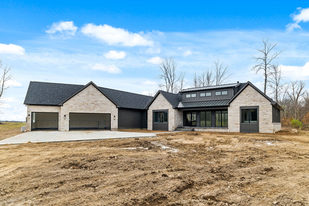 Exterior of custom built home with black roof and light colored stone